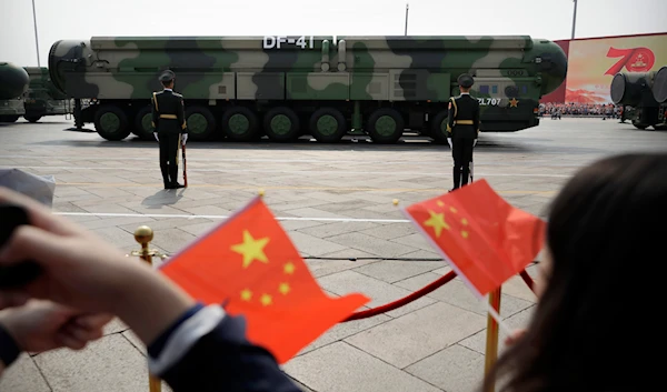 Spectators wave Chinese flags as military vehicles carrying DF-41 nuclear ballistic missiles roll during a parade to commemorate the 70th anniversary of the founding of Communist China in Beijing on Oct. 1, 2019.(AP)