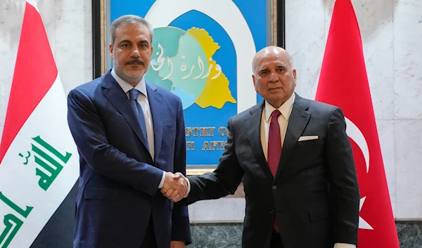 Iraqi Foreign Minister Fouad Hussein, right, shakes hands with visiting Turkish Foreign Affairs Minister Hakan Fidan in Baghdad, Iraq, Thursday, March 14, 2024.(AP)