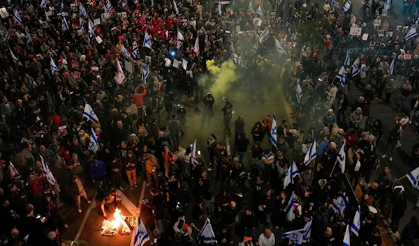 Relatives of the Israeli hostages held in Gaza block a road during a rally calling for their release, in 'Tel Aviv', occupied Palestine, Saturday, March 16, 2024 (AP)