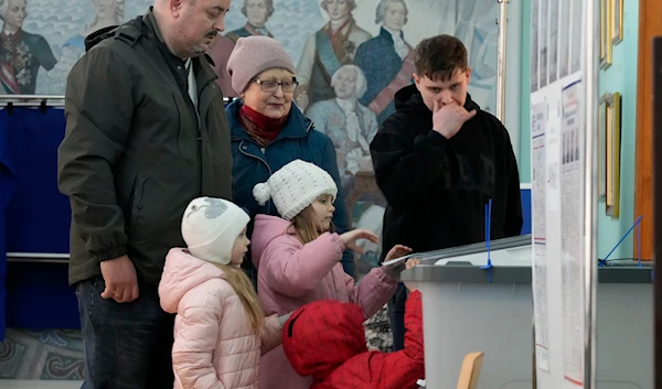 A family votes at a polling station located in a school during the presidential elections in St. Petersburg, Russia, Saturday, March 16, 2024. (AP)