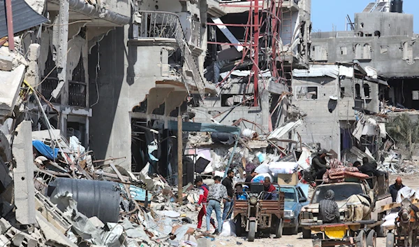 Palestinians collect belongings from their homes destroyed by the Israeli offensive on Khan Younis, Gaza Strip, Friday, March 8, 2024.(AP)