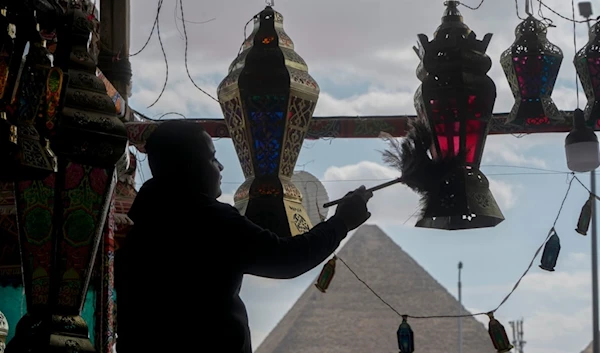 A worker prushes traditional lanterns at a shop in front of Giza Pyramids ahead of the upcoming Muslim fasting month of Ramadan, in Cairo, Egypt, Thursday, March 7, 2024. (AP)