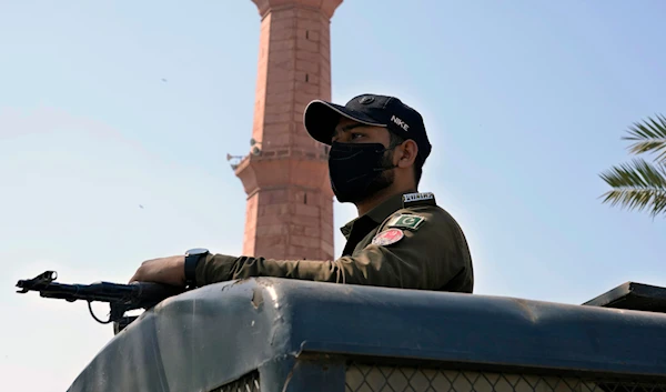 A police officer stands alert on the top of a vehicle outside the historical Badshahi mosque in Lahore, Pakistan, Friday, March 15, 2024. (AP)