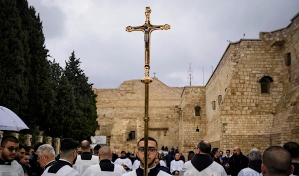 Catholic clergy walk in procession next to the Church of the Nativity, on Christmas Eve, in the West Bank city of Beit Lahm, occupied Palestine, Dec. 24, 2023. (AP)