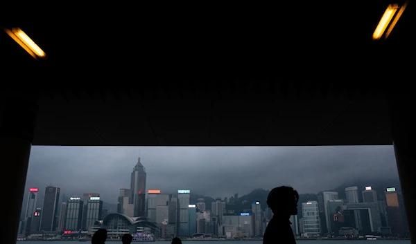 Pedestrians walk along promenade next to Victoria Harbour in Hong Kong, Monday, March 11, 2024.