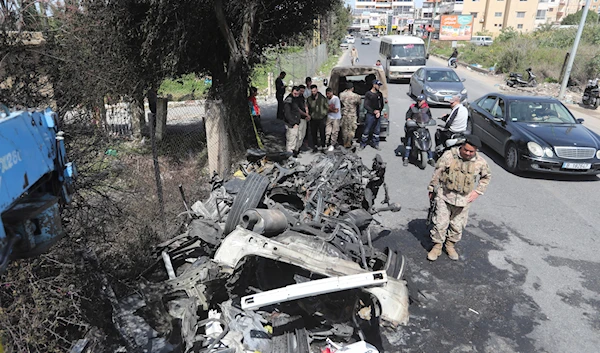 Lebanese army soldiers stand next to the car targeted by an Israeli drone on the southern outskirts of Tyre, Lebanon, Wednesday, March 13, 2024.(AP)