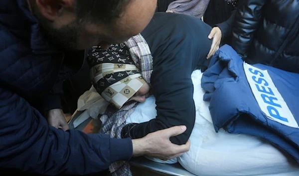 A relative mourns Palestinian journalist Akram al-Shafi’I, killed in the Israeli bombardment of the Gaza Strip, in a morgue of the European Gaza Hospital in Rafah, Saturday Jan.6, 2024. (AP)