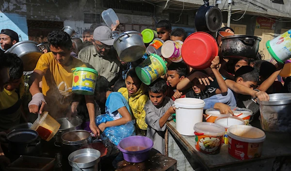 Palestinians crowd together as they wait for food distribution in Rafah, southern Gaza Strip, November 8, 2023 (AP)