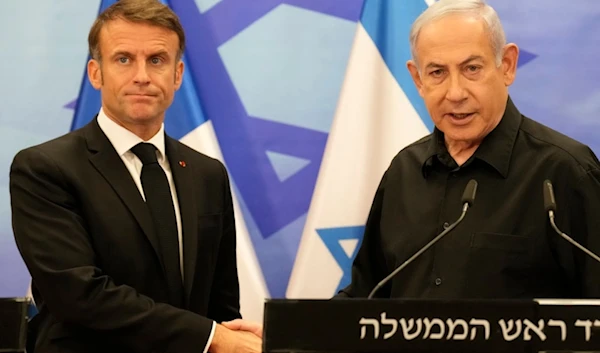 Israeli Prime Minister Benjamin Netanyahu, right, shakes hands with French President Emmanuel Macron after a joint press conference in occupied al-Quds, Tuesday, Oct. 24, 2023. (AP)