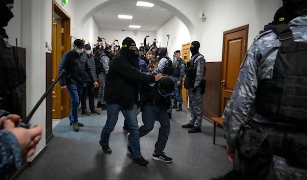 A suspect in the Crocus City Hall shooting on Friday is escorted by police officers in the Basmanny District Court, in Moscow, Russia, Sunday, March 24, 2024. (AP Photo/Alexander Zemlianichenko)