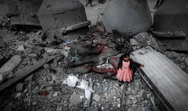 A Palestinian girl wearing a pink dress stands amidst the ruins of the Al-Faruq Mosque that was destroyed during Israeli bombardment, in Rafah on the southern Gaza Strip on March 22, 2024. (AFP via Getty Images)