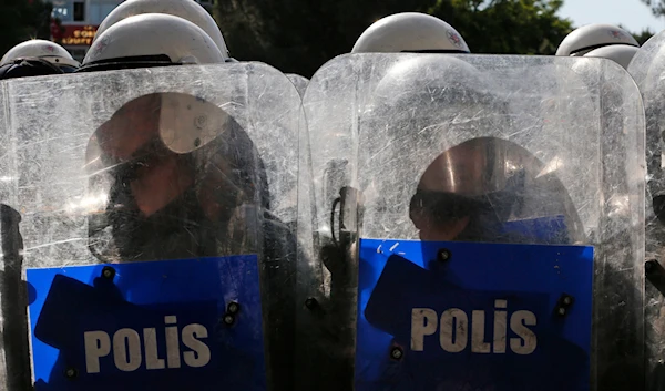 Turkish police officers stand guard during clashes with anti-government protesters in Soma, Turkey where the mine accident took place, Friday, May 16, 2014. (AP)