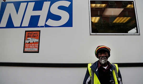 In this Wednesday, Oct. 16, 2013 photo, volunteer Horace Reid, 58, waits outside an X-ray van, parked outside a homeless shelter, in London. (AP)