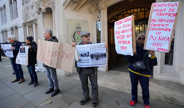 Protesters stand outside the Supreme Court in London, Wednesday, Nov. 15, 2023. Britain's highest court is set to rule Wednesday, Nov. 15 on whether the government's plan to send asylum-seekers to Rwanda is legal.(AP)