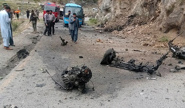 Police officers examine the site of the suicide bombing at a highway in Shangla, a district in Pakistan's Khyber Pakhtunkhwa province, Tuesday, March 26, 2024. (AP)