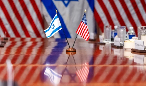 An Israeli and US flag are reflected on a conference table as Defense Secretary Lloyd Austin meets with Israeli Security Minister Yoav Gallant, at the Pentagon, March 26, 2024, in Washington. (AP)