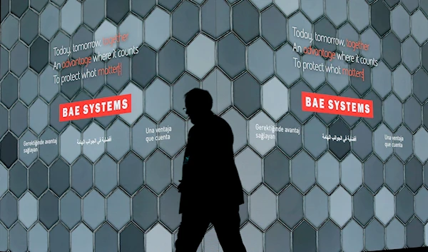 A man walks past a screen in the BAE Systems chalet at the Farnborough Airshow in Farnborough, England, on July 16, 2018. (AP)