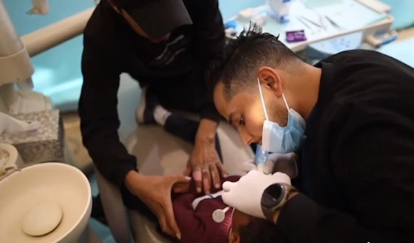 Screengrab showing Doctor Najadt Saqer performing an medical procedure on a child in a tent in Gaza. (Asknews)