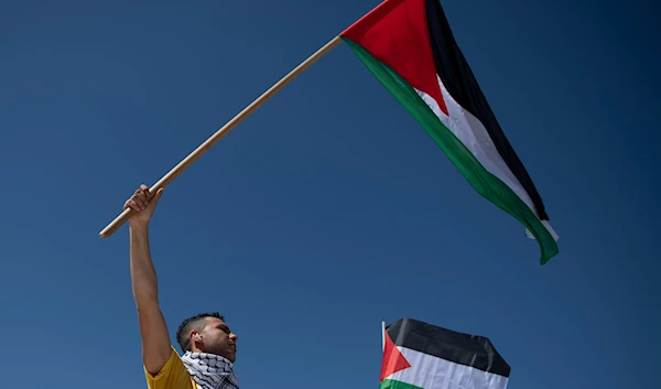 A man waves a Palestinian flag during a protest rally at Syntagma Square, Athens, Greece, Saturday, March 30, 2024. (AP)