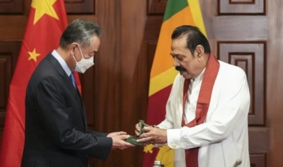 Sri Lankan Prime minister Mahinda Rajapaksa right presents a souvenir to Chinese foreign minister Wang before their meeting in Colombo, Sri Lanka, Sunday, January 9, 2022. (AP)