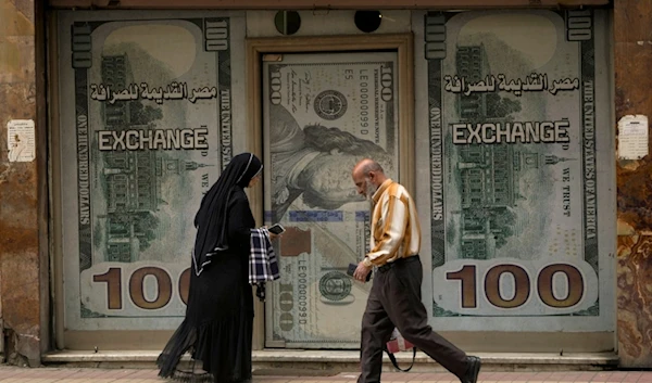 Egyptians walk past an exchange office in Cairo, Egypt, Wednesday, March 6, 2024. (AP)