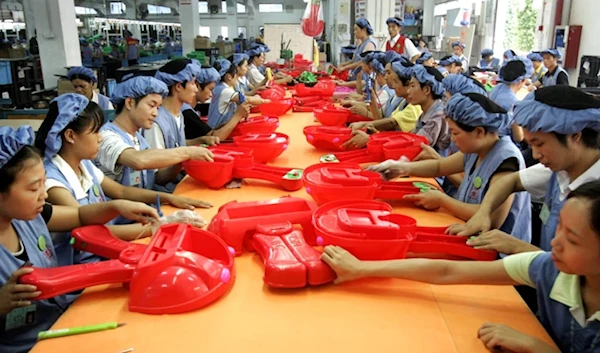 Workers assemble toy cars at the production line of Dongguan Da Lang Wealthwise Plastic Factory in Dongguan, China. (AP)