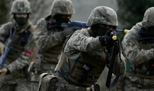 Ukrainian recruits under the guidance of British soldiers train at an army camp in South West England, Tuesday, Feb. 20, 2024. The recruits were being instructed on urban warfare. (AP)