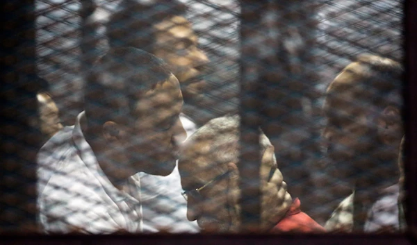 Muslim Brotherhood spiritual leader Mohammed Badie is greeted by other group members at the defendants cage in a makeshift courtroom at the Torah prison, southern Cairo, Egypt, July 21, 2015 (AP)