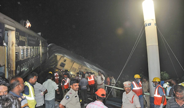 Rescuers and others stand after two passenger trains collided in Vizianagaram district, Andhra Pradesh state, India, Sunday, Oct.29, 2023.(AP)