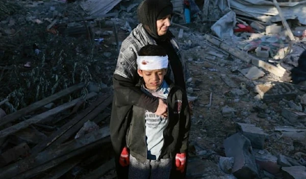 A Palestinian mother embraces a lightly-injured boy as they check the rubble of a residential building following Israeli bombardment, January 18, 2024 in Rafah in the southern Gaza Strip. (AFP)