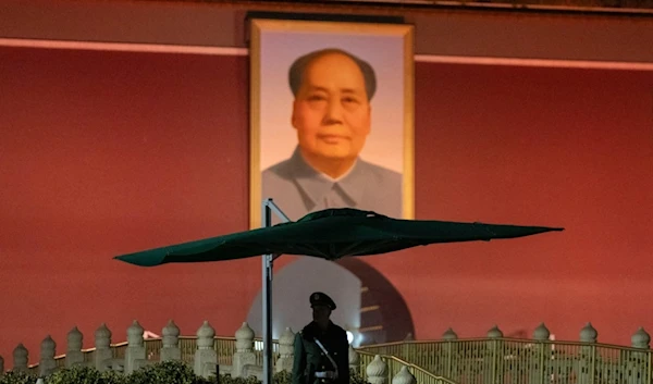 A Chinese paramilitary policeman stands guard near the portrait of Mao Zedong on Tiananmen Gate before the opening session of the National People's Congress (NPC) in Beijing, China, Tuesday, March 5, 2024. (AP)