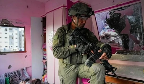 An Israeli occupation soldier vandalizes a Palestinian home during current genocide in Gaza. (AFP)