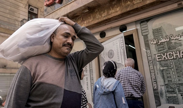 An Egyptian man walks past an exchange office in Cairo, Egypt, Wednesday, March 6, 2024. (AP)