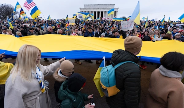 Ukrainians and their supporters carry a huge Ukrainian flag during a rally at the National Mall near the Lincoln Memorial in Washington, Saturday, Feb. 24, 2024. (AP)