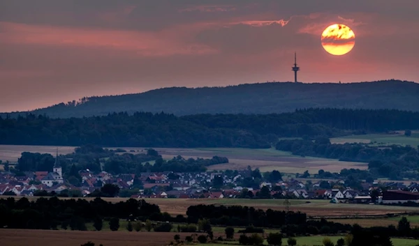 The sun rises over the village of Wehrheim near Frankfurt, Germany, Thursday, Aug. 10, 2023. (AP Photo/Michael Probst)