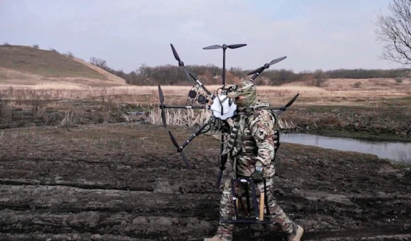 Monday, March 25, 2024, a Russian soldier carries a captured Ukrainian drone restored and modernized by the military at an undisclosed location in Ukraine (AP)