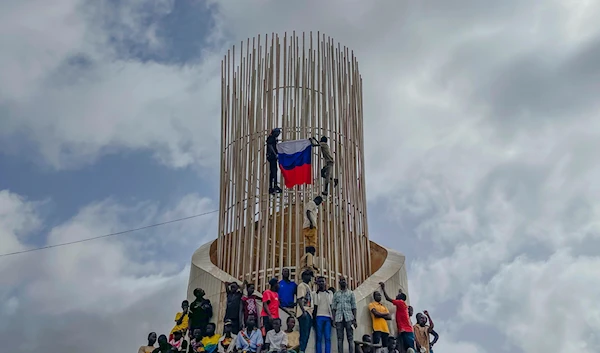 Supporters of Niger's ruling junta hold a Russian flag at the start of a protest in Niamey, Niger, on Aug. 3, 2023. (AP)