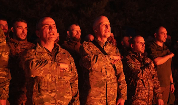 Soldiers of Ukraine's National Guard 3rd Svoboda (Liberty) battalion, Rubezh (Frontier) brigade pray as they stand around a fire during rotation in Ukraine, Thursday, April 11, 2024. (AP)