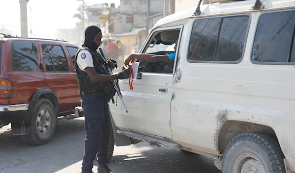 A police officer checks a driver documents at an intersection in Port-au-Prince, Haiti, Saturday, April 6, 2024. (AP)