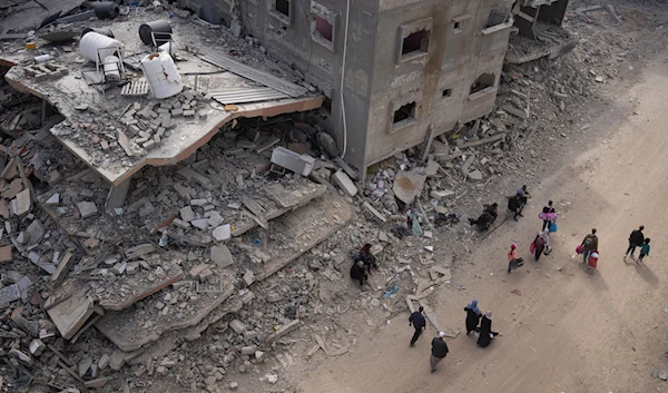 Palestinians walk through the destruction in the wake of an Israeli air and ground offensive in Khan Younis, southern Gaza Strip, Monday, April 8, 2024. (AP)