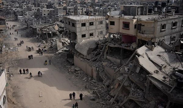 Palestinians walk through the destruction in the wake of an Israeli air and ground offensive in Khan Younis, southern Gaza Strip, Monday, April 8, 2024. (AP)