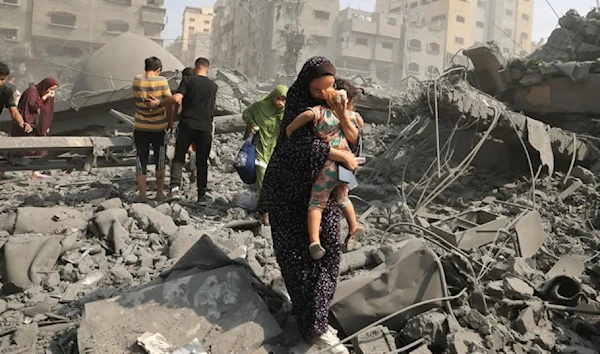 Palestinian mother and her child evacuate following an Israeli airstrike on the Sousi Mosque in Gaza on Oct. 9. (AFP  via Getty Images)