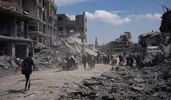 Palestinians walk through the destruction in the wake of an Israeli air and ground offensive in Khan Younis, southern Gaza Strip, Monday, April 8, 2024. (AP)