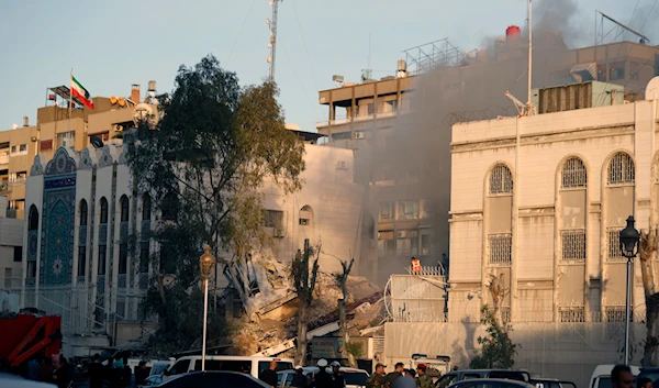 Emergency services work at a destroyed building hit by an air strike in Damascus, Syria, April 1, 2024 (AP)