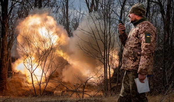 A Ukrainian officer observes the firing of a 152-mm Self-Propelled Howitzer 2S3, towards Russian positions at the frontline, near Bakhmut, Donetsk region, Ukraine, Monday, March 25, 2024. (AP)