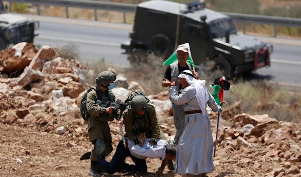 Israeli occupation forces detain a Palestinian man during a protest against the expansion of Israeli settlements in the village of Khirbet Jubarah near the West Bank city of Tulkarm, Thursday, Aug. 20, 2020. (AP)