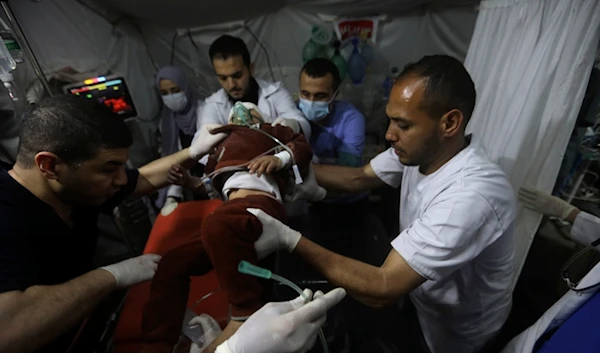 Palestinian medics carry a young wounded in the Israeli bombardment of the Gaza Strip, to the Kuwaiti Hospital in Rafah refugee camp, southern Gaza Strip, April 20, 2024 (AP Photo/Ismael Abu Dayyah)