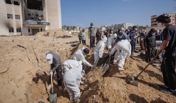 Palestinian health workers unearth a body buried by Israeli forces inside Nasser hospital compound in Khan Younis in the southern Gaza Strip on April 21, 2024. (AFP)