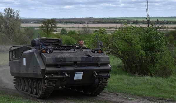 A Ukrainian serviceman with the 65th Brigade rides in an armored vehicle at the frontline in Zaporizhye region, Ukraine, Sunday, April 21, 2024. (AP Photo/Andriy Andriyenko)