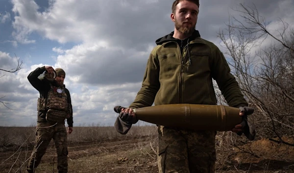 Ukrainian soldiers carry shells to fire at Russian positions on the front line, near the city of Bakhmut, in the Donetsk region, on March 25, 2024 (AP)